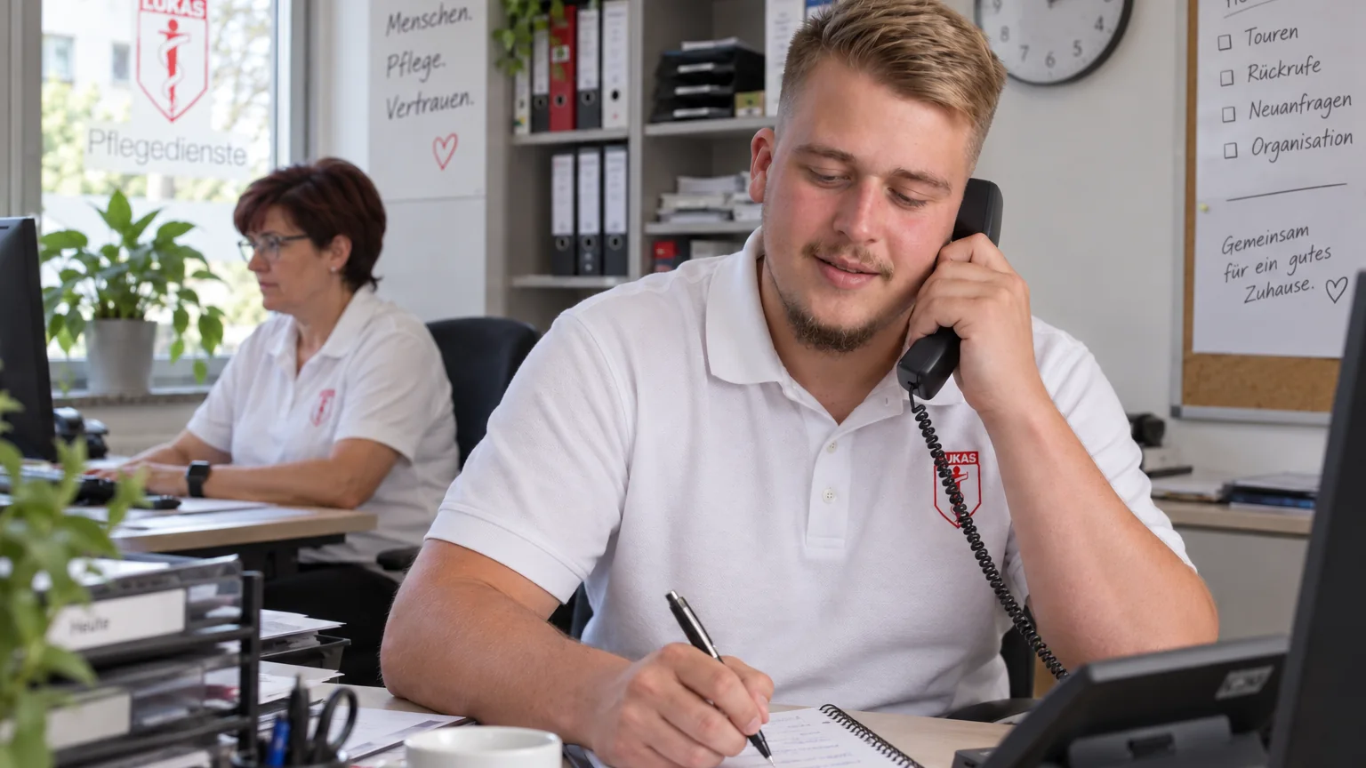 Mitarbeiter beantwortet im St.-Lukas-Büro telefonisch Fragen zu Pflegeleistungen.