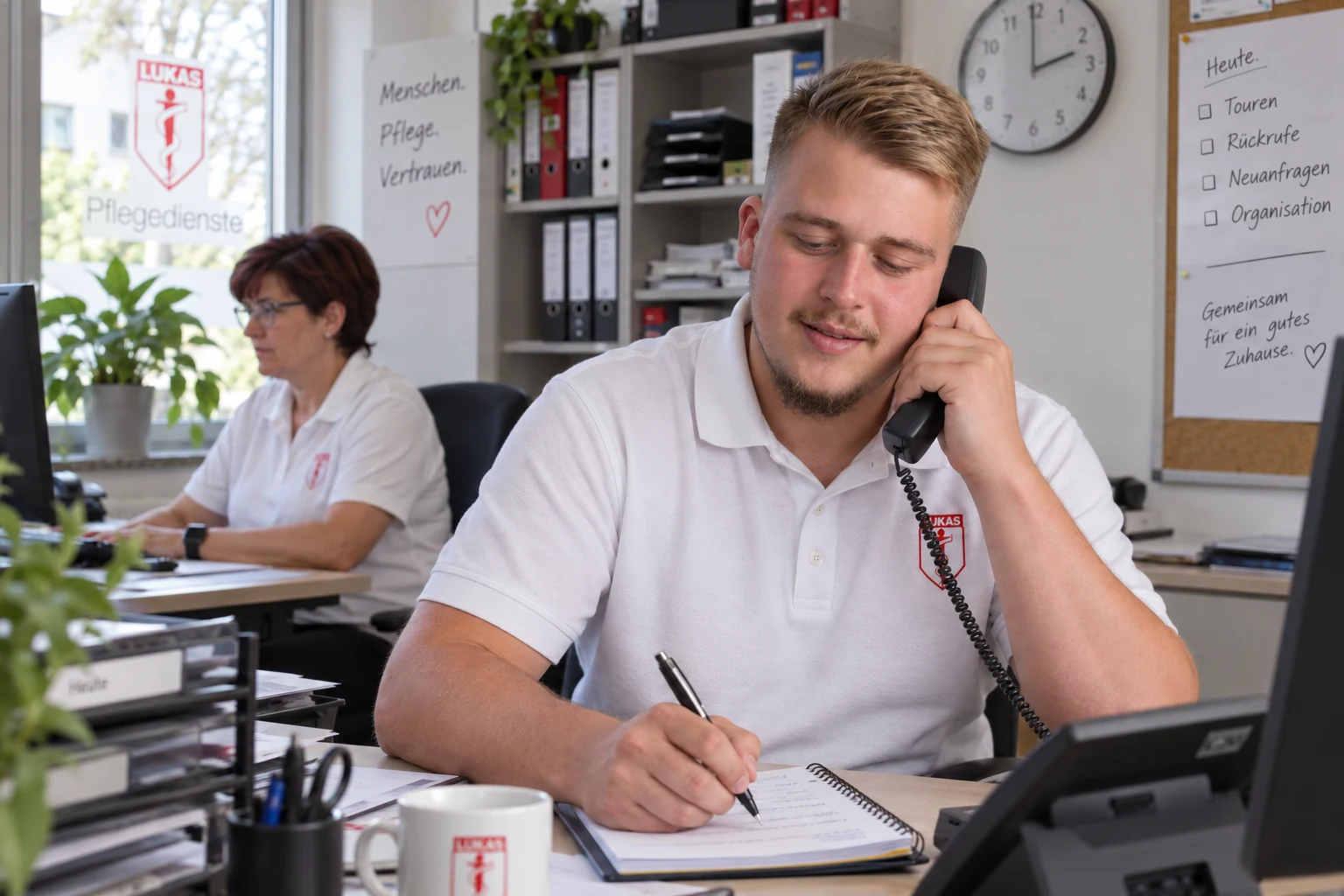 Ein Mitarbeiter von St. Lukas nimmt im Büro telefonisch ein Anliegen auf.